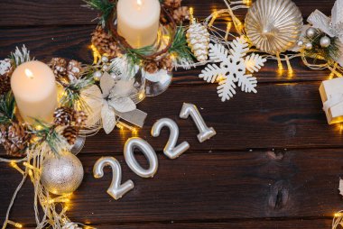 Noel süsleri, aksesuarlar ve çelenklerle süslenmiş kahverengi Noel arkaplanı. Şenlikli yeni yıl kartı