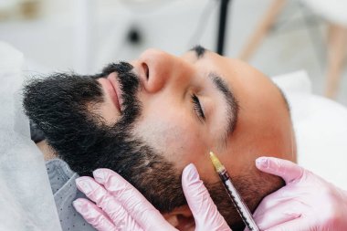 Dudak büyütme ve sakallı bir adam için kırışıklık giderme için estetik ameliyat. Kozmetoloji