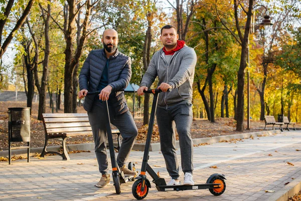 Fiatal Srácok Kocsikáznak Parkban Egy Elektromos Robogón Egy Meleg Őszi — Stock Fotó