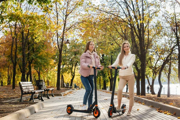 Twee Jonge Mooie Meisjes Rijden Elektrische Scooters Het Park Een — Stockfoto