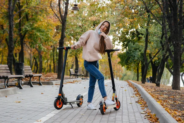 Egy Fiatal Gyönyörű Lány Maszkban Lovagol Parkban Egy Elektromos Robogón — Stock Fotó