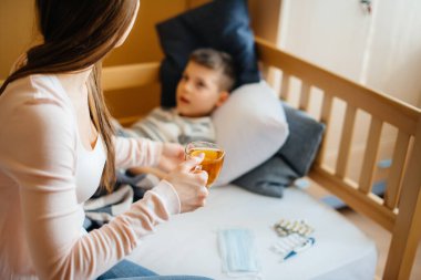 Anne hastalık ve virüs sırasında bebeğine limonlu sıcak çay verir. İlaç ve bakım