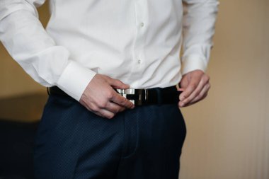 Şık genç adam kol düğmelerinin düğmelerini ilikliyor. Biçim