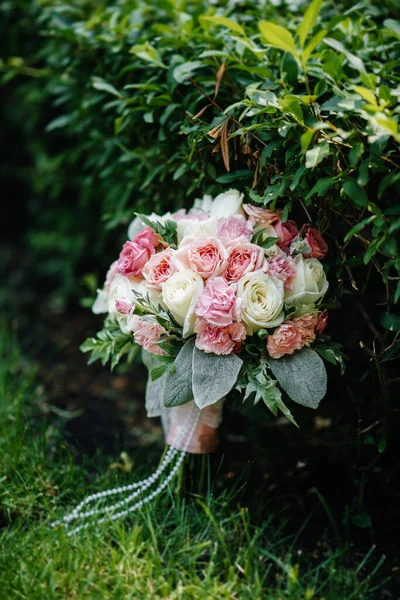 夏日的绿草上挂着美丽的婚礼花束 — 图库照片