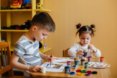 Bir erkek ve bir kız birlikte oynayıp resim yapıyorlar. Eğlence ve eğlence. Evde kal.