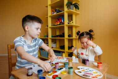 Bir erkek ve bir kız birlikte oynayıp resim yapıyorlar. Eğlence ve eğlence. Evde kal.