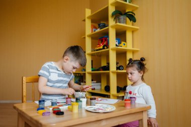 Bir erkek ve bir kız birlikte oynayıp resim yapıyorlar. Eğlence ve eğlence. Evde kal.