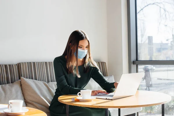 Una Joven Está Sentada Café Usando Una Máscara Trabajando Una — Foto de Stock