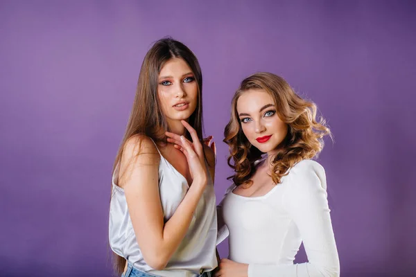 Duas Meninas Jovens Bonitas Mostram Emoções Sorrisos Estúdio Fundo Roxo — Fotografia de Stock