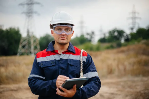 Bir enerji işçisi elektrik hatlarını kontrol eder. Enerji