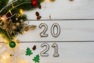 Beyaz Noel arkaplanı şenlikli dekorlar, fenerler, kar taneleri ve Noel ağacı dallarıyla süslenmiş. Noel tebrik kartı. Kış tatili. Mutlu yıllar.