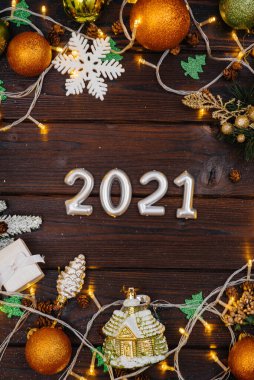 Noel süsleri, aksesuarlar ve çelenklerle süslenmiş kahverengi Noel arkaplanı. Şenlikli yeni yıl kartı