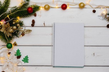 Beyaz Noel arkaplanı şenlikli dekorlar, fenerler, kar taneleri ve Noel ağacı dallarıyla süslenmiş. Noel tebrik kartı. Kış tatili. Mutlu yıllar.