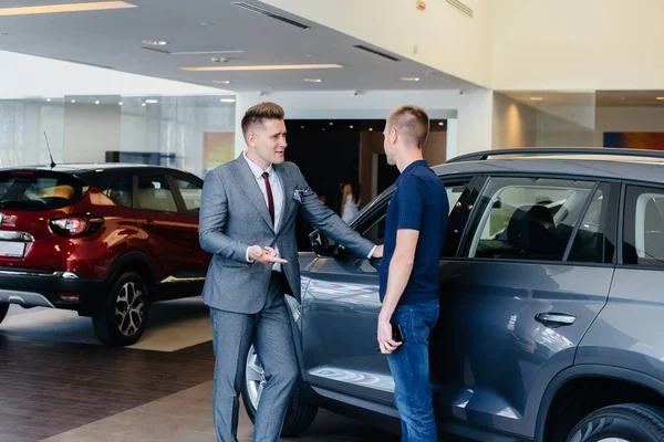 Joven Hombre Negocios Con Vendedor Mira Coche Nuevo Concesionario Automóviles —  Fotos de Stock