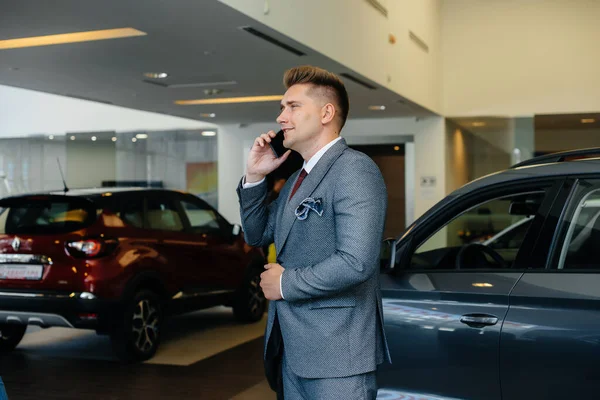 若いビジネスマンは新しい車を買った後に電話をかける — ストック写真