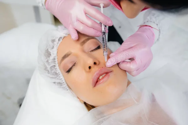 Cosmetology procedure for lip augmentation and wrinkle removal for a young beautiful girl. Cosmetology