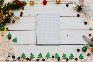 Beyaz Noel arkaplanı şenlikli dekorlar, fenerler, kar taneleri ve Noel ağacı dallarıyla süslenmiş. Noel tebrik kartı. Kış tatili. Mutlu yıllar.