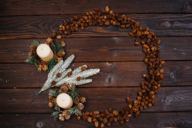 Çember şeklinde kahverengi bir Noel arkaplanı Noel dekorasyonu ve aksesuarları ile süslenir. Bir çelenk. Şenlikli yeni yıl kartı.