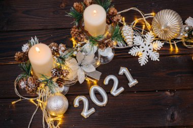 Noel süsleri, aksesuarlar ve çelenklerle süslenmiş kahverengi Noel arkaplanı. Şenlikli yeni yıl kartı