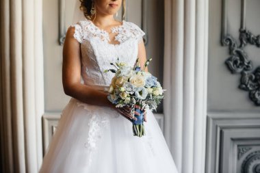 Güzel ve sofistike bir düğün buketi gelini elinde tutuyor. Düğün buketi