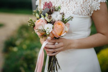 Güzel ve sofistike bir düğün buketi gelini elinde tutuyor. Düğün buketi