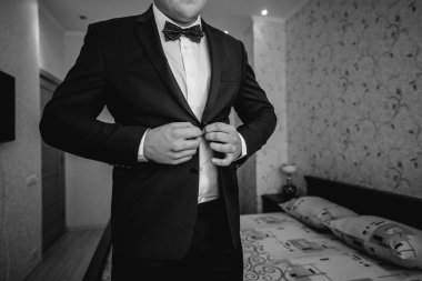 Şık genç adam kol düğmelerinin düğmelerini ilikliyor. Biçim