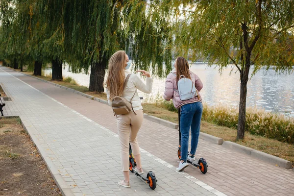 Zwei Junge Hübsche Mädchen Masken Fahren Einem Warmen Herbsttag Elektroroller — Stockfoto