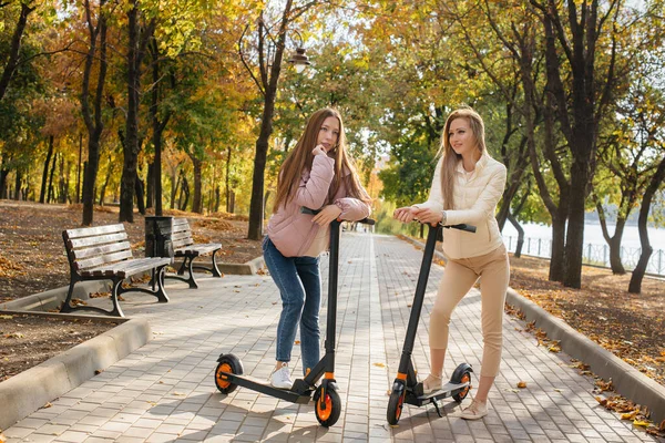 Zwei Junge Schöne Mädchen Fahren Einem Warmen Herbsttag Elektroroller Park — Stockfoto