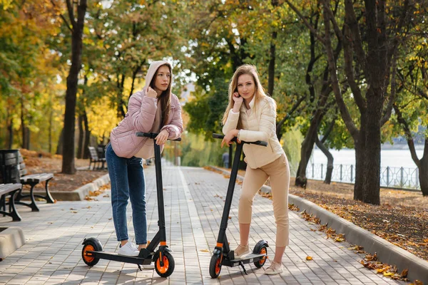 Dvě Mladé Krásné Dívky Jezdit Elektrické Skútry Parku Teplém Podzimním — Stock fotografie