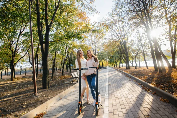 Due Giovani Belle Ragazze Cavalcano Scooter Elettrici Nel Parco Una — Foto Stock