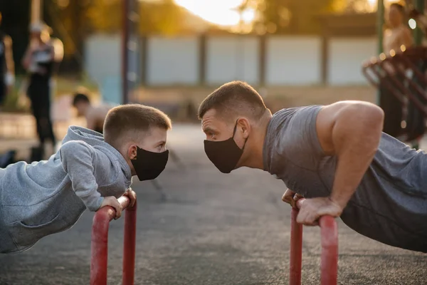 Padre Hijo Practican Deportes Campo Deportes Con Máscaras Durante Atardecer — Foto de Stock