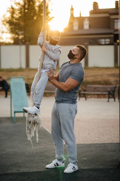 Padre Ayuda Hijo Trepar Una Cuerda Campo Deportes Con Máscaras — Foto de Stock