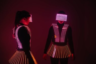 UV kostümlü iki seksi disko dansçısı. Partiler ve danslar.