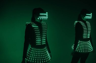 UV kostümlü iki seksi disko dansçısı. Partiler ve danslar.