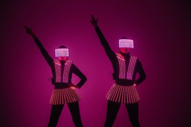 UV kostümlü iki seksi disko dansçısı. Partiler ve danslar.