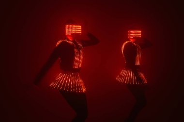 UV kostümlü iki seksi disko dansçısı. Partiler ve danslar.