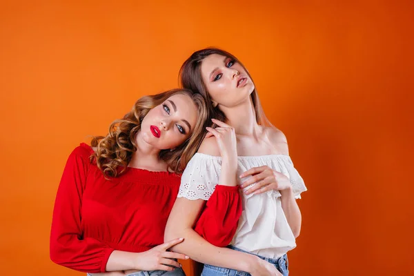 Duas Meninas Jovens Bonitas Mostram Emoções Sorrisos Estúdio Fundo Laranja — Fotografia de Stock