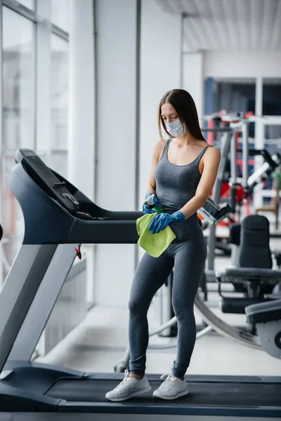 Het Meisje Met Het Masker Desinfecteert Fitnessapparatuur Tijdens Een Pandemie — Stockfoto