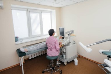 Hamile bir kız klinikte karnının ultrasonuna giriyor. Tıbbi muayene