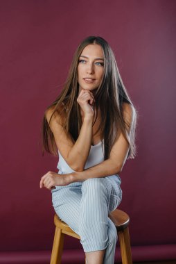 Stüdyoda sandalyede poz veren güzel seksi kız. Moda.