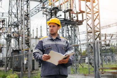 Enerji mühendisi istasyonun ekipmanlarını inceler. Güç mühendisliği. Sanayi