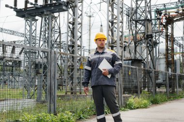 Bir mühendis modern bir elektrik santralini gezip teftiş ediyor. Enerji. Sanayi