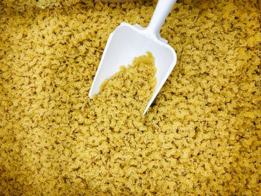 Büyük bir kutu İtalyan makarnası ve beyaz bir kepçe yakın çekim. Yiyecek.