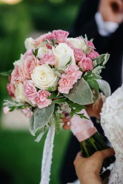 Güzel ve sofistike bir düğün buketi gelini elinde tutuyor. Düğün buketi