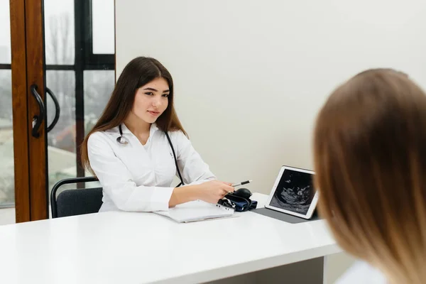 A young couple at a gynecologist\'s consultation after an ultrasound. Pregnancy, and health care