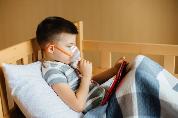 在肺吸入过程中 一个男孩在平板上玩耍 医药和护理 — 图库照片