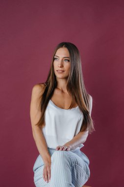 Stüdyoda sandalyede poz veren güzel seksi kız. Moda.