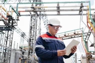 Enerji mühendisi istasyonun ekipmanlarını inceler. Güç mühendisliği. Sanayi