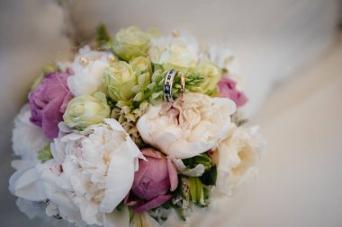 Alyanslar güzel bir düğün buketine yakın plan. Düğün aksesuarları