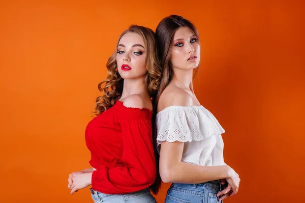 Duas Meninas Jovens Bonitas Mostram Emoções Sorrisos Estúdio Fundo Laranja — Fotografia de Stock